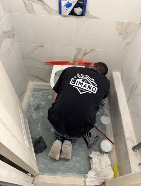 Plombier Limano Dépanne installant un WC suspendu sur bâti-support